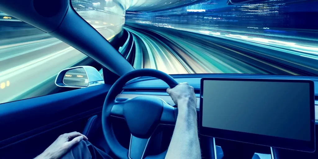 A man driving a Mazda CX-50 with a screen on the dashboard, using remote start with key fob.